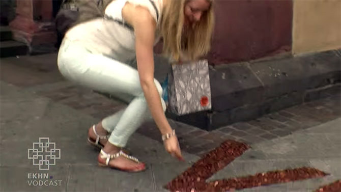 A passerby adds money to the social sculpture